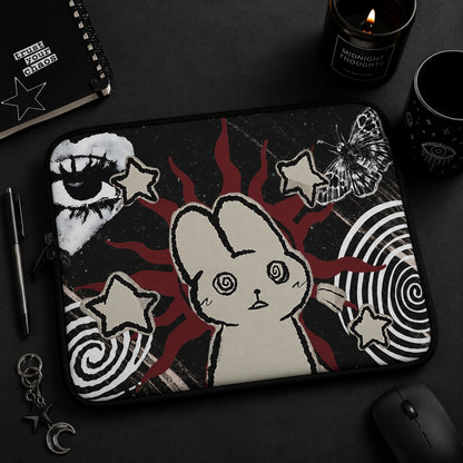 Alternative fashion model holding a gothic laptop sleeve with hypnotic bunny artwork, butterfly illustration, celestial motifs and dark grunge aesthetic.