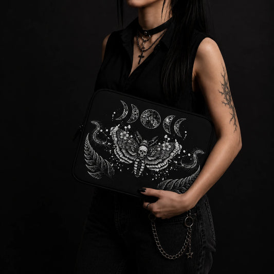 Gothic death moth laptop sleeve with skull moth illustration, lunar phases and botanical details, held by alternative goth woman wearing black outfit.