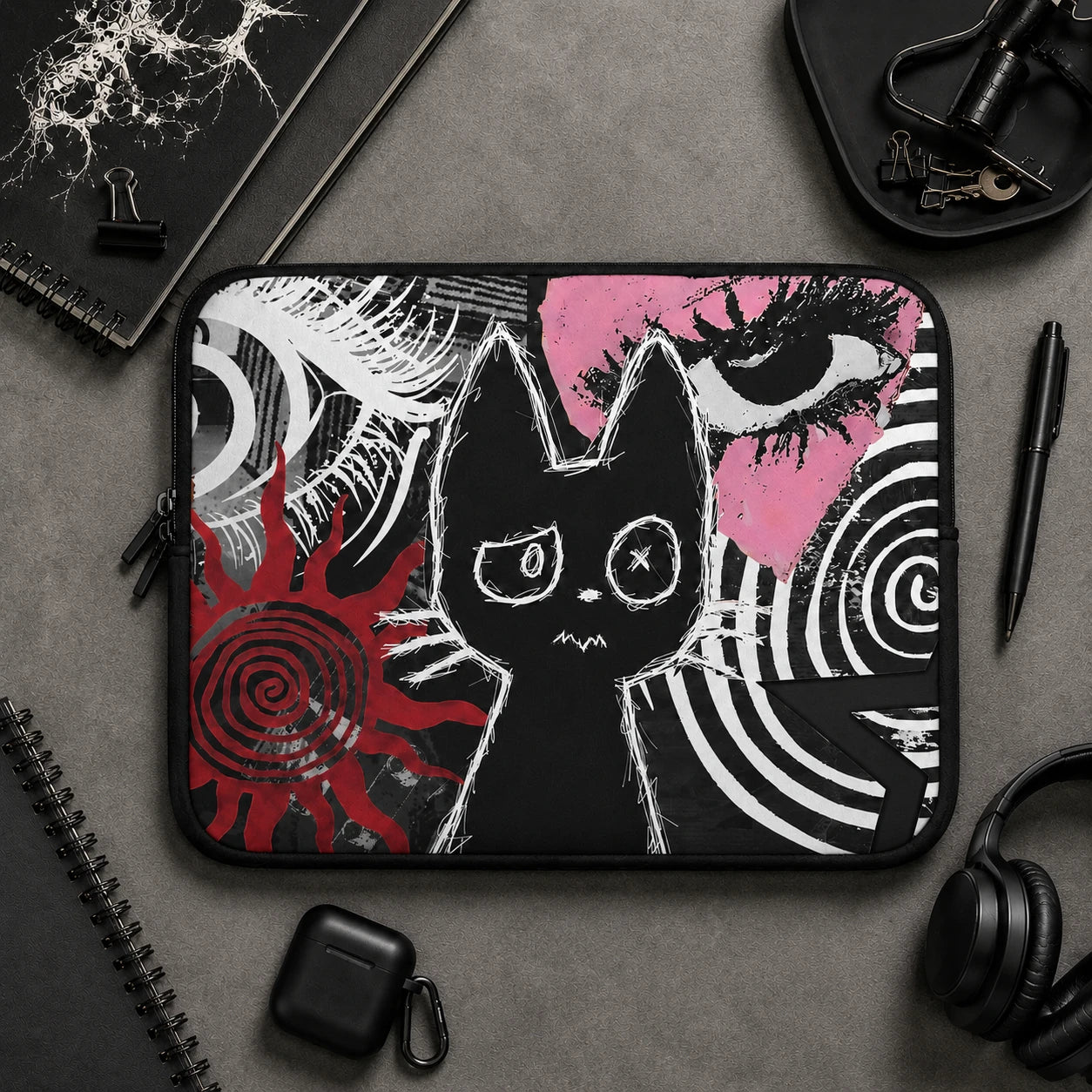 Alternative gothic laptop sleeve with black cat illustration, red and white grunge elements, spiral artwork, and dark aesthetic design. Protective padded laptop case displayed in a realistic product mockup for gothic and emo desk setups.