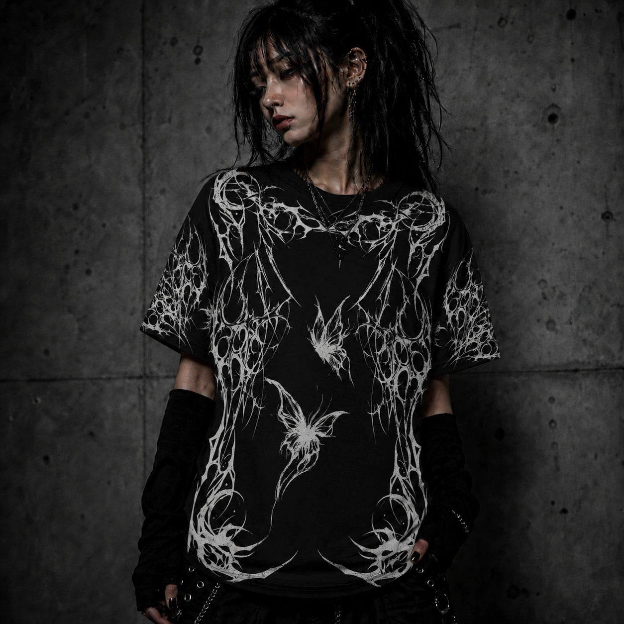 Female model wearing oversized gothic butterfly graphic t-shirt with dark fairycore and gothic fashion aesthetic.