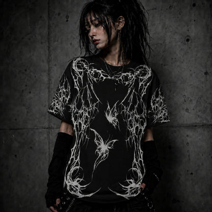 Female model wearing oversized gothic butterfly graphic t-shirt with dark fairycore and gothic fashion aesthetic.
