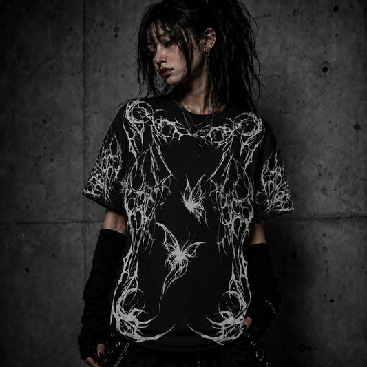 Female model wearing oversized gothic butterfly graphic t-shirt with dark fairycore and gothic fashion aesthetic.