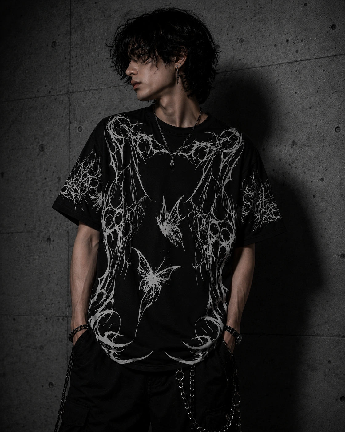 Male model wearing oversized gothic butterfly graphic t-shirt with dark grunge and alternative fashion style.