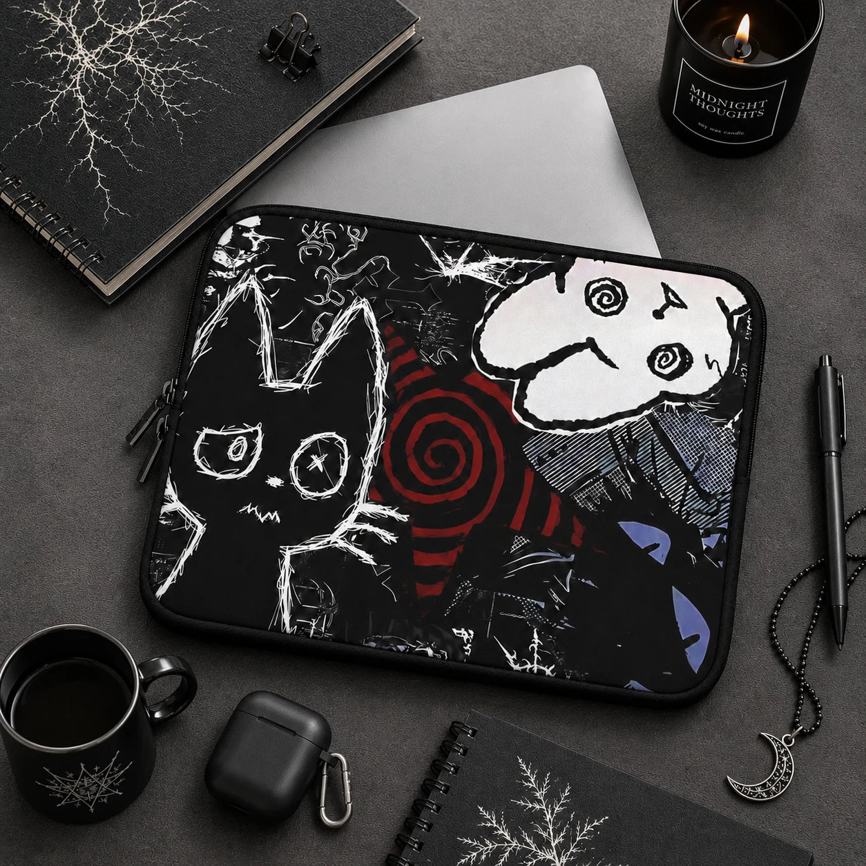 Gothic cat laptop sleeve featuring creepy cute black and white cat artwork, dark alternative desk setup with black accessories and gothic aesthetic decor.