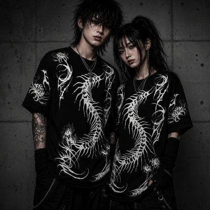 Alternative fashion couple wearing matching oversized black gothic t-shirts with white centipede skeleton artwork and spider lily details.