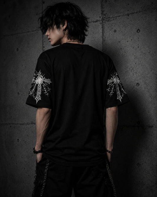 Back view of oversized black gothic t-shirt with white sleeve graphics in dark alternative fashion aesthetic.