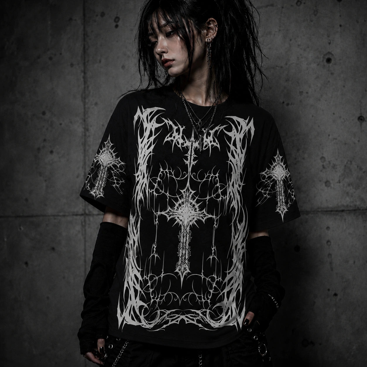 Female model wearing oversized black gothic cross graphic t-shirt with intricate white artwork in gothic alternative fashion style.