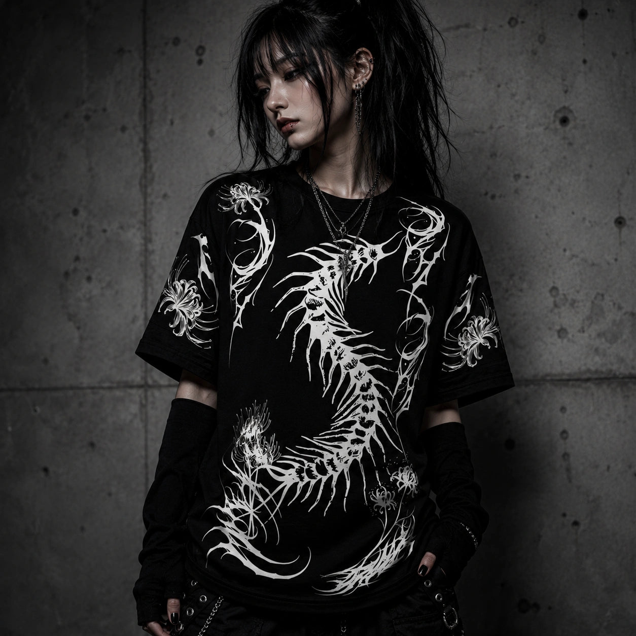 Female model wearing oversized black gothic t-shirt with white centipede skeleton graphic and spider lily artwork in alternative fashion aesthetic.