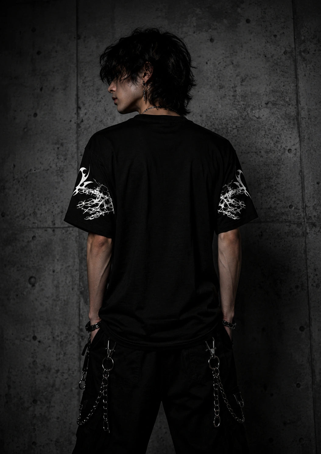 Back view of oversized black gothic t-shirt with sleeve graphics and relaxed unisex fit.