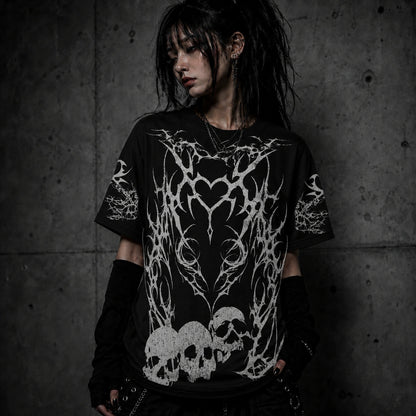 Female model wearing black gothic oversized t-shirt featuring tribal heart artwork and distressed skull graphics.