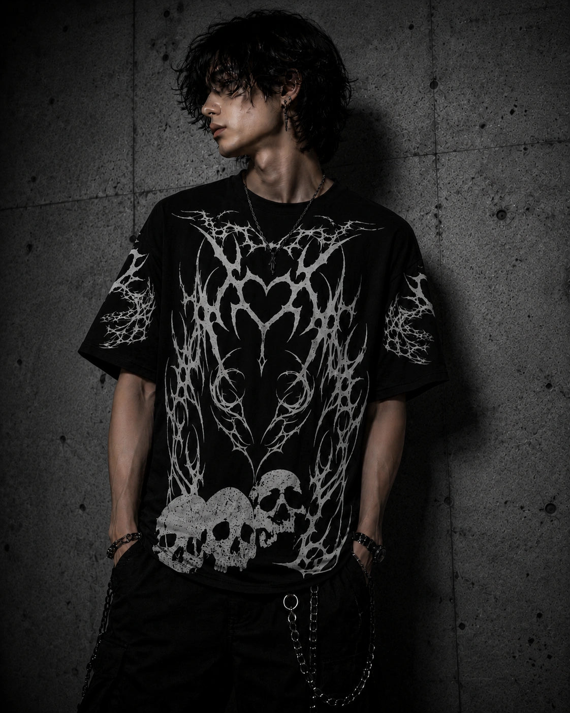 Male model wearing oversized gothic skull shirt with tribal heart design and grunge streetwear aesthetic.