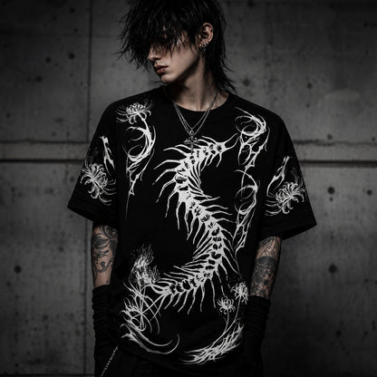 Male model wearing oversized black gothic graphic t-shirt featuring a large white centipede skeleton design in dark streetwear style.