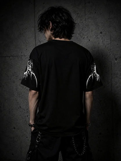 Back view of oversized black gothic streetwear t-shirt with sleeve graphics in a dark alternative fashion setting.