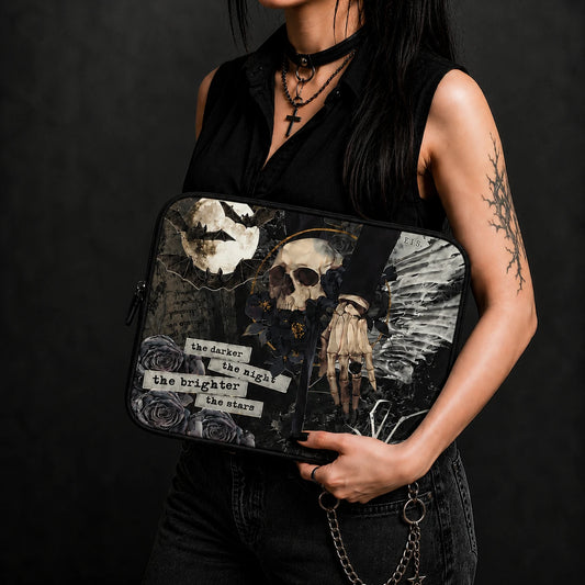 Gothic laptop sleeve featuring skull, bats, black roses, skeletal hand and dark celestial artwork, held by an alternative fashion model wearing black clothing and gothic accessories.