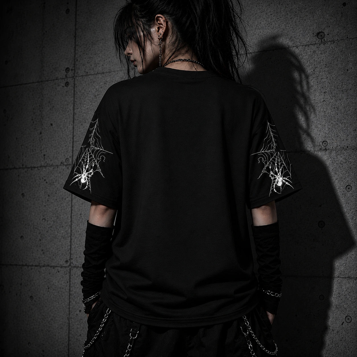Back view of oversized black gothic spider web t-shirt showing detailed spider web sleeve graphics and relaxed fit.