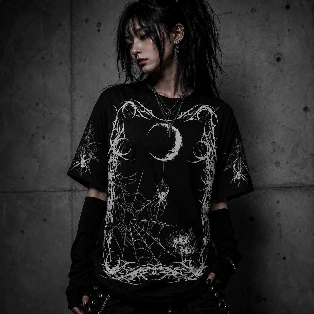 Female model wearing oversized gothic spider web graphic t-shirt with moon and spider design in dark alternative fashion aesthetic.
