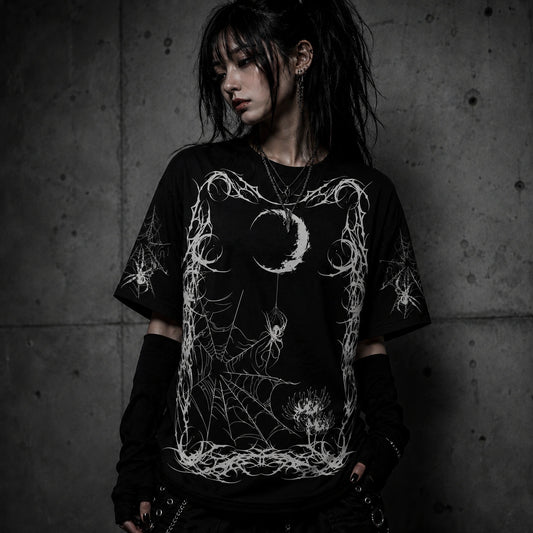 Female model wearing oversized gothic spider web graphic t-shirt with moon and spider design in dark alternative fashion aesthetic.