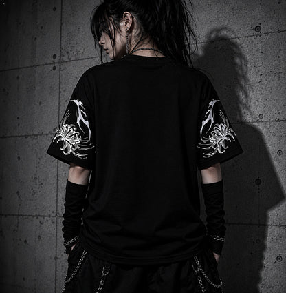 Back view of oversized black gothic streetwear t-shirt featuring white spider lily sleeve artwork in a dark alternative fashion setting.