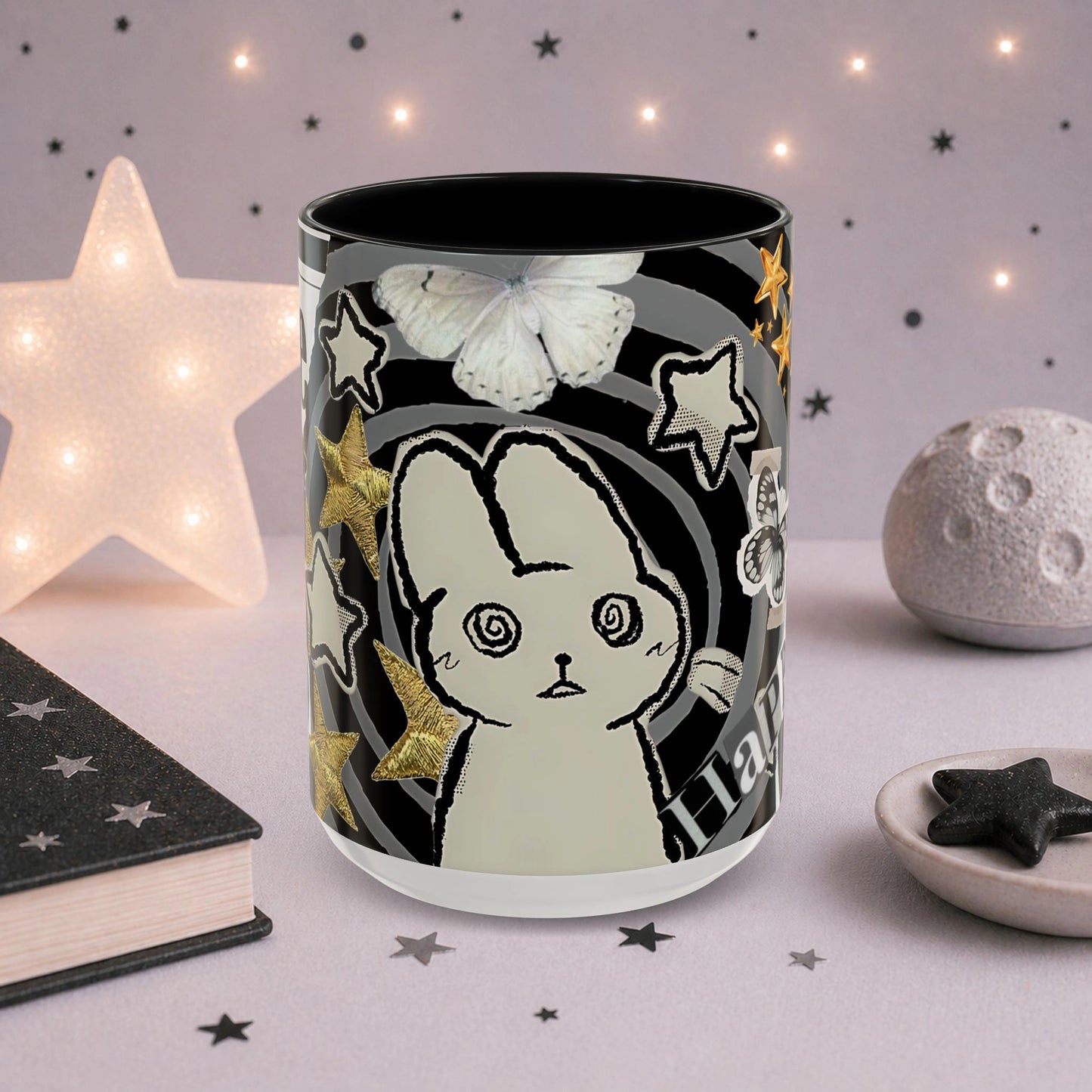 Cute weirdcore mug featuring a spiral-eyed cat character, butterfly illustration, stars and surreal scrapbook collage artwork.