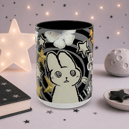 Cute weirdcore mug featuring a spiral-eyed cat character, butterfly illustration, stars and surreal scrapbook collage artwork.
